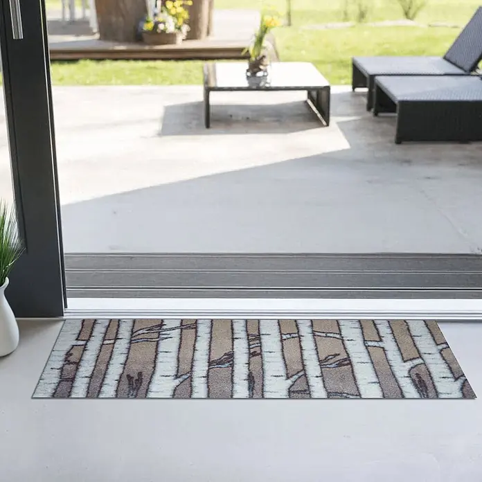 Akzente Fußmatte Feel - Mehrfarbig, Motiv / Muster - Rechteckige Matte mit Birkenmuster in Braun, Weiß und Blaugrau, platziert an der Schwelle einer Terrassentür.