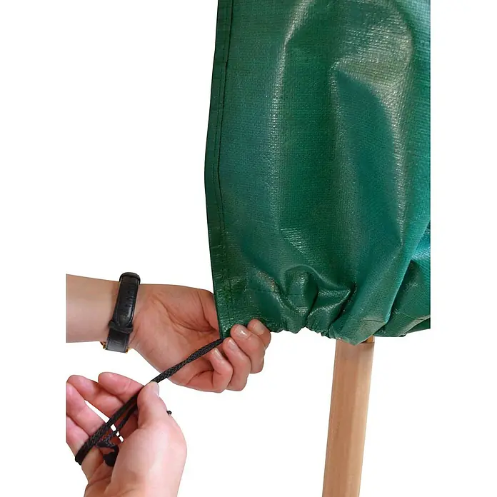 Schutzhülle Sonnenschirm 215 cm für Schirme bis d= 3,5 Universal -  - Hände ziehen Kordelzug einer grünen, texturierten Schutzhülle um einen Holzpfahl fest.