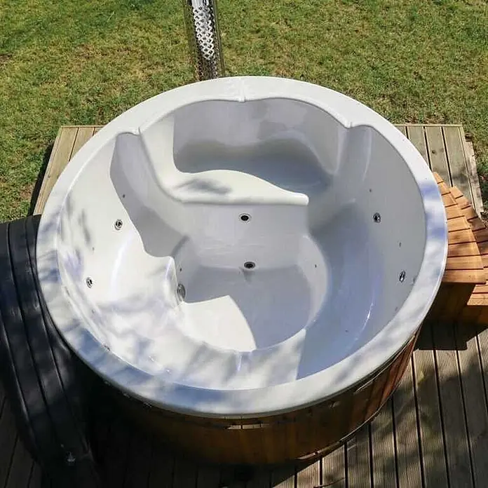 Loocone Hot Tub Hot Tub Acryl 200 cm V4A Holzofen - 200 cm, Max. Personenzahl: 5 Stk. - Runder weißer Whirlpool mit Holzverkleidung, im Freien auf einer Holzterrasse.