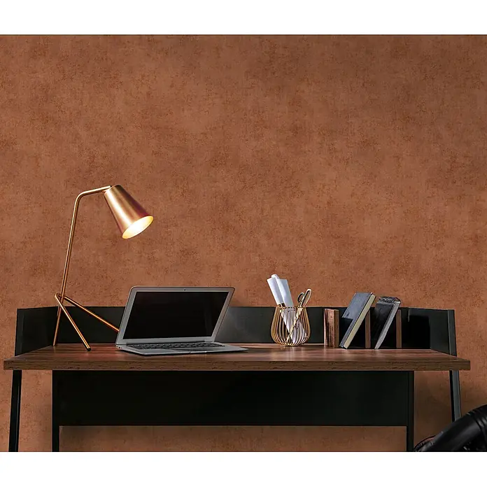 Papel pintado Texturado - Rojo arcilla, 10 x 0,53 m - Escritorio de madera oscura con marco negro, portátil, lámpara dorada y papelería frente a pared marrón.