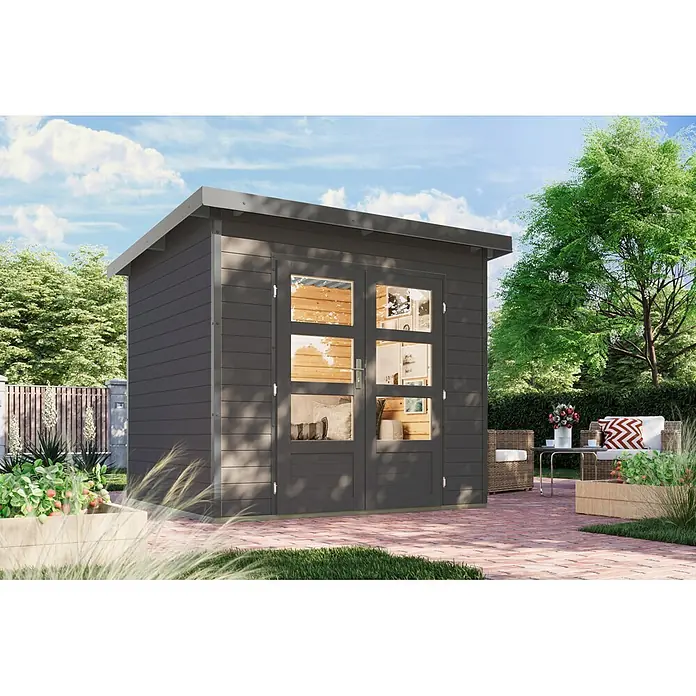 Karibu Gartenhaus Pluto 2 B - Außenmaß inkl. Dachüberstand (B x T): 267 x 228 cm, Holz, Terragrau/Grau - Dunkelgraues Gartenhaus mit Glastüren, Flachdach und hellem Holzinterieur, auf einer Ziegelterrasse mit Gartenmöbeln und Pflanzen.