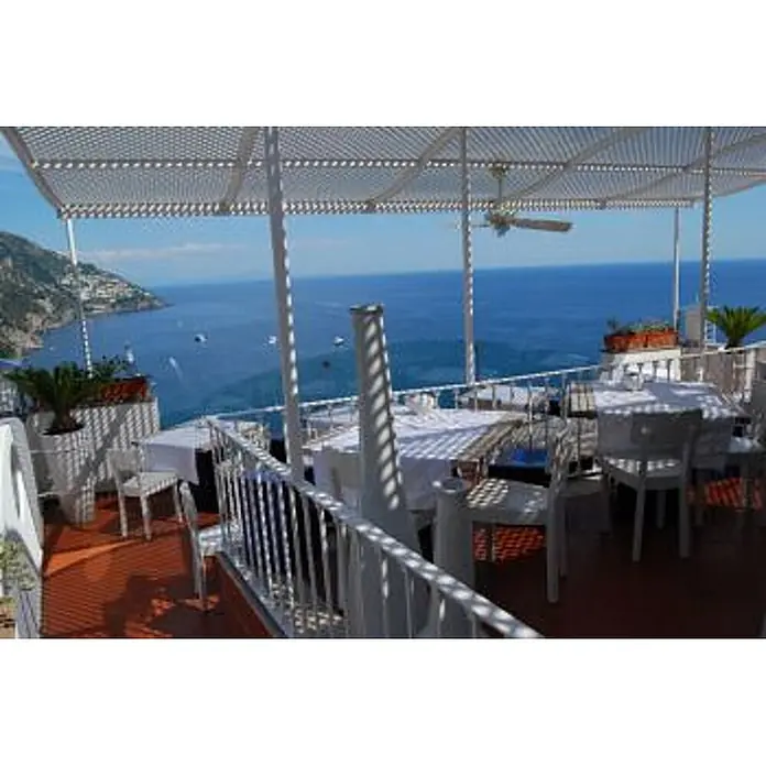 Vam Deckenventilator Outdoor Ventilator Patio weiß mit Licht 132 cm - WEIß, 1.320 mm, 60 W - Freiterrasse eines Restaurants mit weißen Tischen und Stühlen unter einer Pergola, mit Panoramablick auf das Meer und die Küstenstadt.