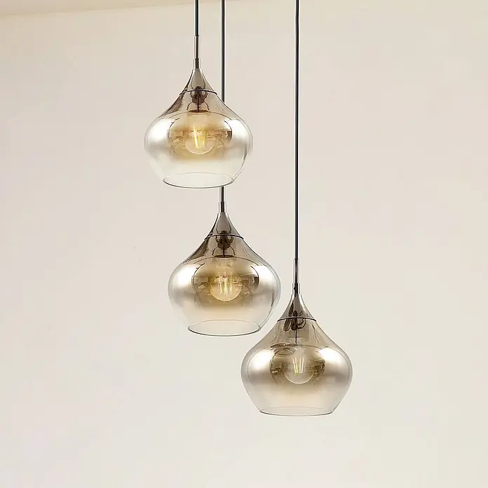 Lucande Pendelleuchte Jarven - L x B x H: 44 x 44 x 17,5 cm, alu / grau / zink, rauchgrau, Schwarz, E27 - Drei Pendelleuchten mit bernsteinfarbenen Glasschirmen und Metallbeschlägen, die in verschiedenen Höhen hängen.