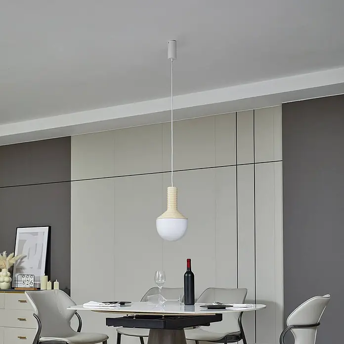 Lucande Pendelleuchte Florine - creme / amber, beige, opal, E27 - Moderne Pendelleuchte mit weißem Baldachin, weißer Schnur, geripptem hellem Holzaufsatz und kugelförmiger weißer Glasschirm über einem Esstisch.
