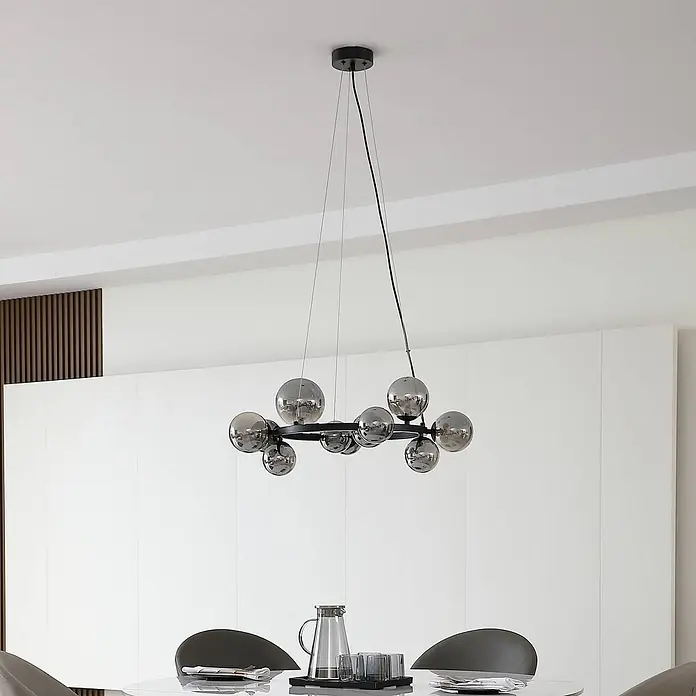 Lucande Pendelleuchte Naelen - L x B x H: 64,3 x 52,8 x 120 cm, alu / grau / zink, Schwarz, rauchgrau, G9 - Moderner schwarzer Metallring-Kronleuchter mit Rauchglas-Kugeln, über einem Esstisch hängend.
