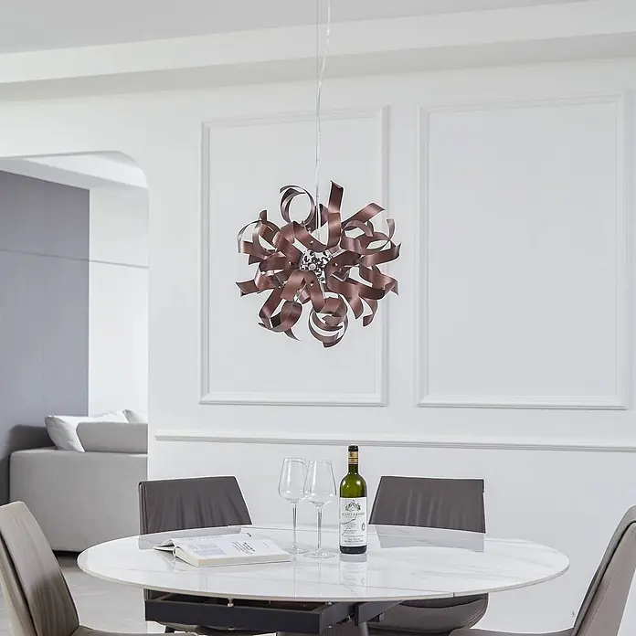 Lucande Pendelleuchte Kaelor - L x B x H: 46 x 46 x 46 cm, kupfer, satin Kupfer, G9 - Bronze-farbene Metallband-Pendelleuchte mit abstraktem, kugelförmigem Design, über einem weißen Esstisch hängend.