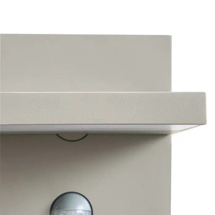 Lucande Außenwandleuchte Silvan - alu / grau / zink, alu / grau / zink, IP54 - Hellbeiges, texturiertes Paneel mit integrierter LED-Beleuchtung und Sensor darunter.