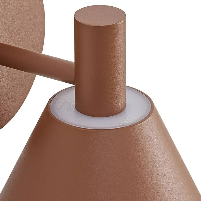 Lucande Außenwandleuchte Tabena - braun / rost, braun / rost, IP54 - Nahaufnahme einer matten braunen Wandleuchte mit zylindrischem Arm und konischem Schirm, mit einem weißen, durchscheinenden Ring.