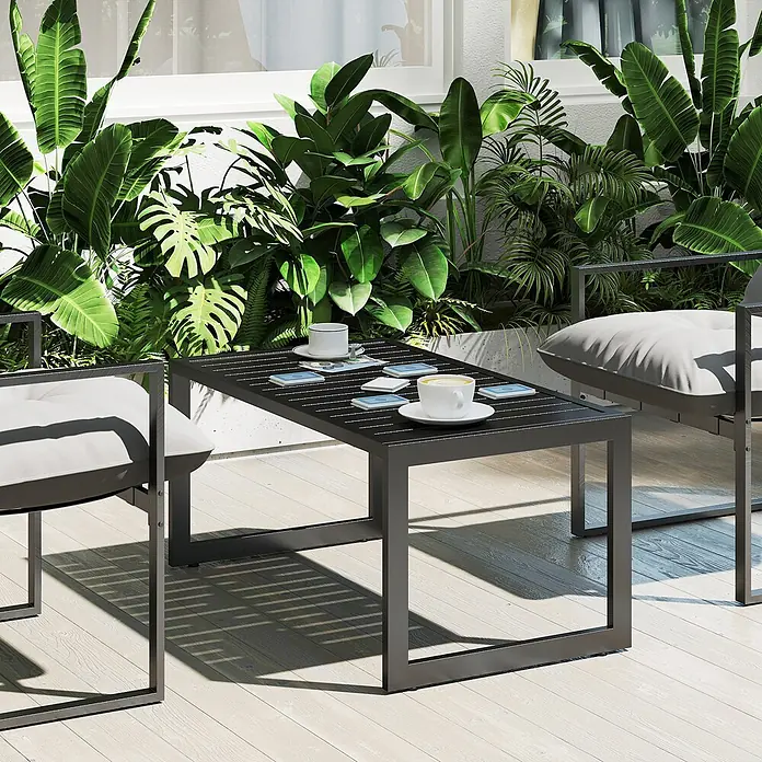 Outsunny Garten-Loungetisch mit verstellbaren Fußpolster - Aluminium, Schwarz, L x B x H: 90 x 50 x 42 cm - Dunkelgrauer Outdoor-Couchtisch und zwei Sessel mit weißen Kissen auf einer Holzterrasse, umgeben von grünen Pflanzen.