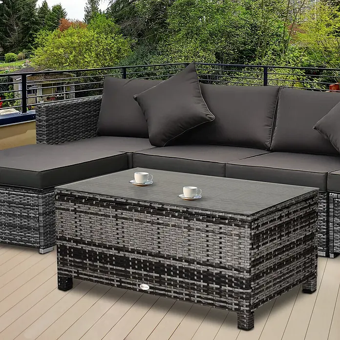 Outsunny Garten-Loungetisch - Metall, PE-Rattan, gehärtetes Glas, Grau - Graues Rattan-Outdoor-Ecksofa mit dunklen Kissen und passendem Couchtisch mit Glasplatte auf einer Terrasse.