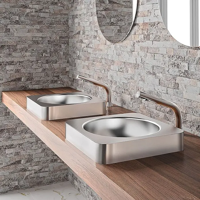 Delabie Waschbecken Delabie - Hahnloch: Mitte, Mit Überlauf, Edelstahl - Zwei moderne, metallische, quadratische Waschbecken mit geschwungenen Armaturen auf einer Holzplatte im Badezimmer.