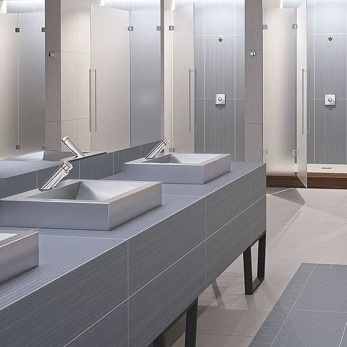 Delabie Waschtisch Delabie - Hahnloch: Mitte, Mit Überlauf, Edelstahl - Moderne graue, quadratische Waschbecken mit Chromarmaturen auf gefliester Waschtischanlage in einem öffentlichen Bad mit Duschkabinen.