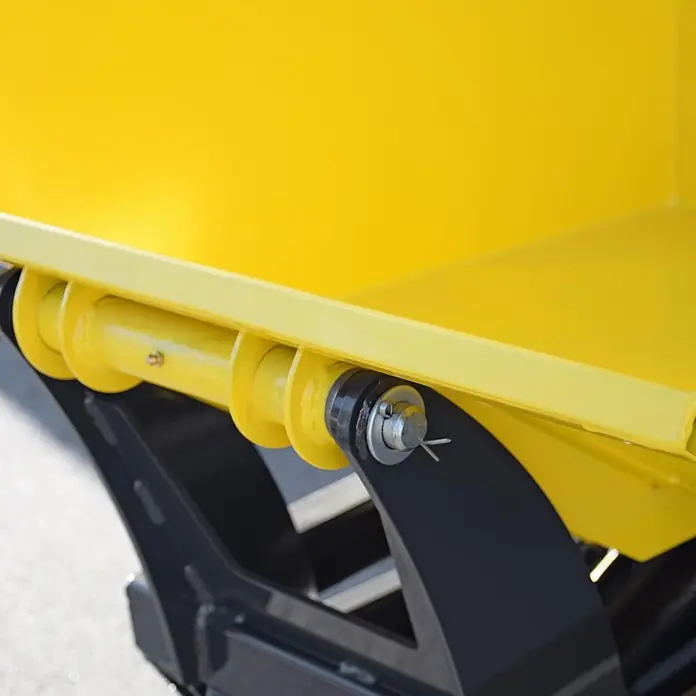Bamato Kettendumper MTR-550PROL mit Liftfunktion - Motorbetrieben, Traglast: 500 kg - Nahaufnahme einer gelben Metall-Anbaugeräte-Scharnierverbindung am schwarzen Rahmen, mit Bolzen und Splint gesichert.