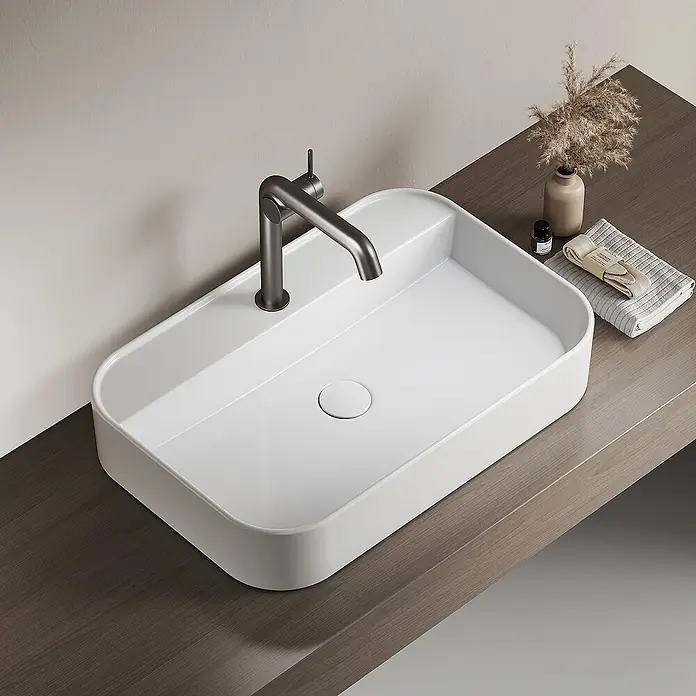 Emke Waschbecken Klyro - B x L: 40 x 60 cm, Hahnloch: Mitte, Ohne Überlauf, Weiß - Modernes, rechteckiges weißes Waschbecken mit abgerundeten Ecken und einem dunkelgrauen Wasserhahn auf einer hellen Holzplatte.