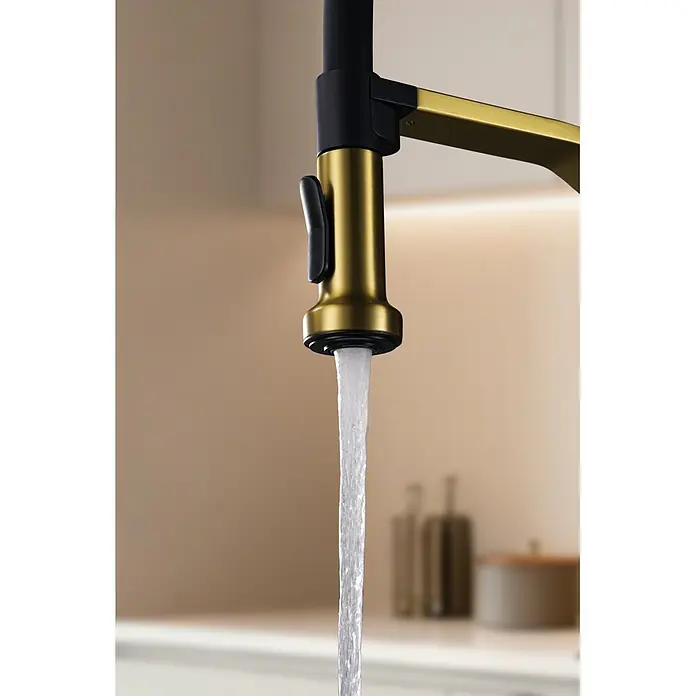 Grifo de cocina Véneto - Oro, Brillante - Agua fluyendo de un grifo de cocina moderno dorado y negro, mostrado en un entorno de cocina.