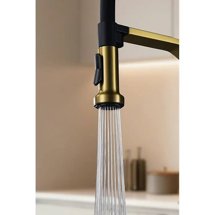 Grifo de cocina Véneto - Oro, Brillante - Primer plano de un grifo de cocina moderno dorado y negro rociando agua.
