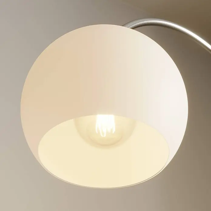 Lindby Stehleuchte Cynthia - alu / grau / zink, E27 - Nahaufnahme eines hellen, kugelförmigen Lampenschirms mit leuchtender Glühbirne an einem Metallarm.