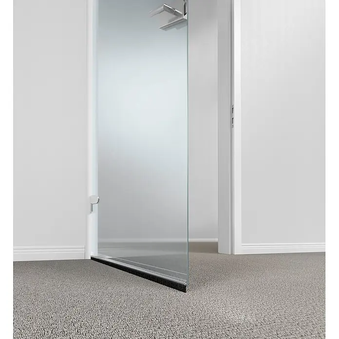 Tesa INSULATION Türdichtschiene für Teppichböden - Weiß, Geeignet für: Spaltenbreiten bis 15 mm - Mattierte Glasschwingtür mit Chromgriff und Bürstendichtung, in einem Raum mit grauem Teppichboden installiert.