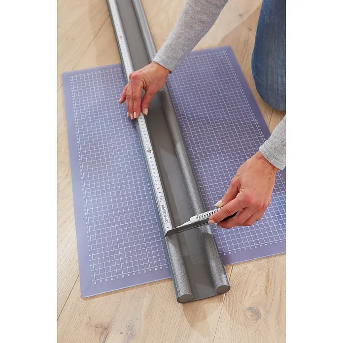 Tesa INSULATION Türbodendichtung Doppel-Dichtung - Grau, 0,95 m x 25 mm, Geeignet für: Glatte Böden - Grauer Schaumstoff-Zugluftstopper wird mit Cuttermesser auf Schneidematte zugeschnitten.