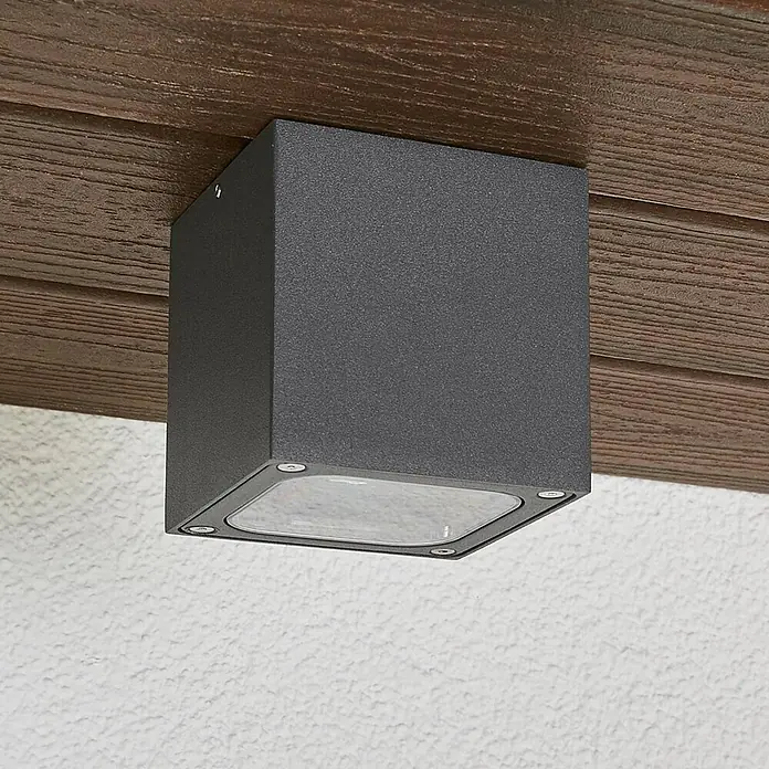 Lucande Außenwand- & Deckenleuchte Tanea - alu / grau / zink, alu / grau / zink, IP54 - Dunkelgraue quadratische Außenleuchte unter einem Holzvorsprung montiert.