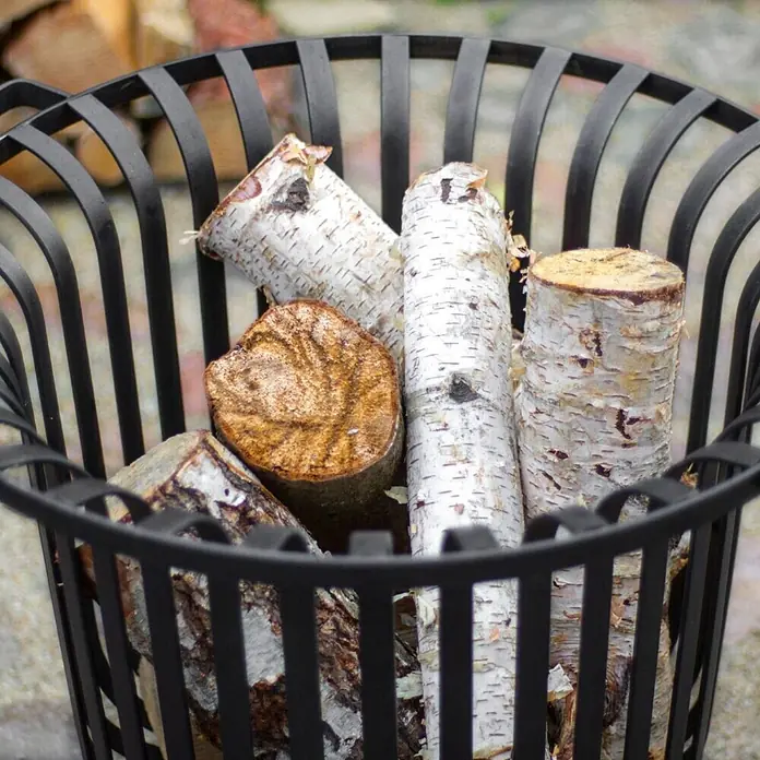 Bene on Fire Holzkohlegrill Tennessee - Schwarz - Schwarzer Metall-Kaminholzkorb, gefüllt mit Birkenholzscheiten, bereit für Kamin oder Feuerstelle.
