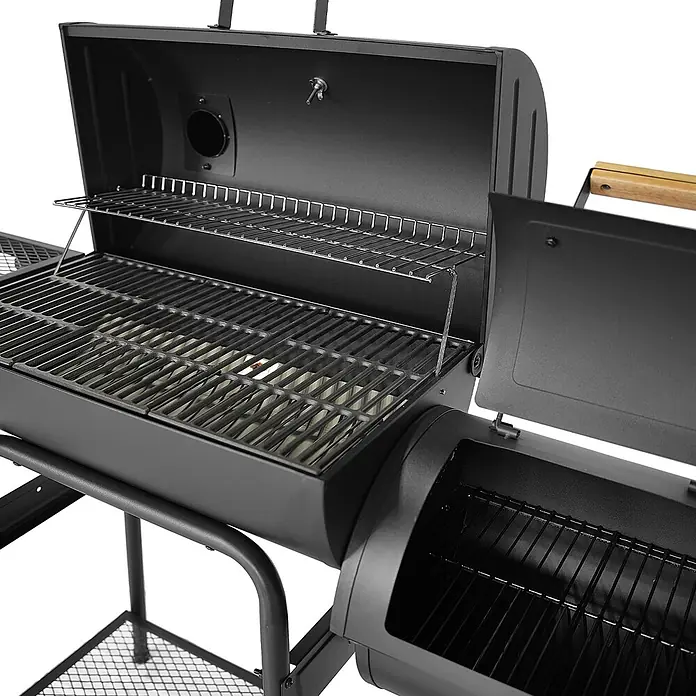 TAINO Smoker KAMAYO - Schwarz - Schwarzer Metall-BBQ-Smoker-Grill mit geöffneter Hauptkammer, die Grillroste und einen Warmhalterost zeigt, sowie eine geöffnete Smokerbox mit Rost.