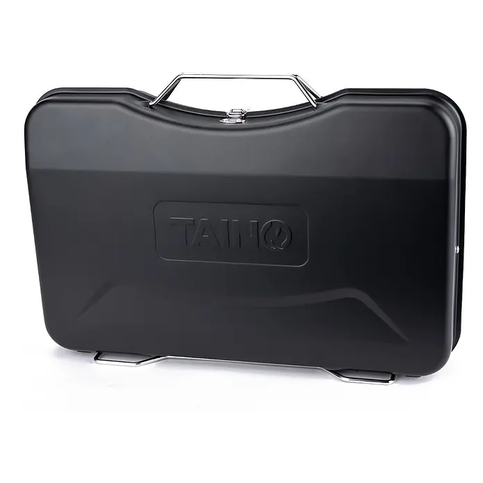 TAINO Holzkohlegrill MOX - Schwarz - Schwarzer tragbarer Grillkoffer mit silbernem Griff und Füßen, geprägtes 'TAINQ' Logo.
