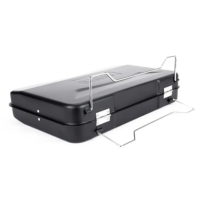 TAINO Holzkohlegrill MOX - Schwarz - Schwarze rechteckige Metall-Grill- oder Räucherbox mit silbernen Drahtgriffen und klappbaren Ständern.