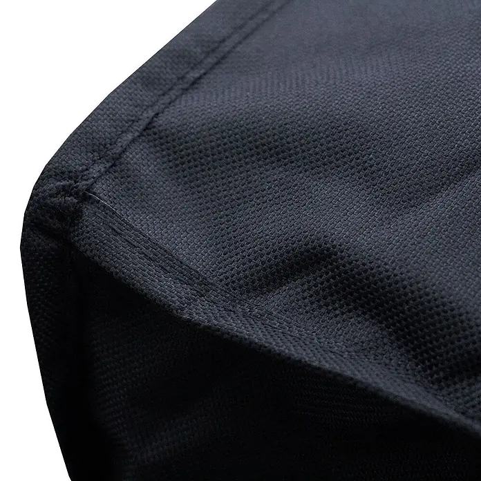 TAINO Grill-Schutzhülle - Passend für: Universal nutzbar - TAINO HERO Holzkohlegrill & TAINO HERO Smoker (93535), Oxford-Polyester, 400D + UV Schutz, 270 g/m², Schwarz - Nahaufnahme von schwarzem Vliesstoff mit sichtbaren Nähten, Teil einer Abdeckung oder Tasche.