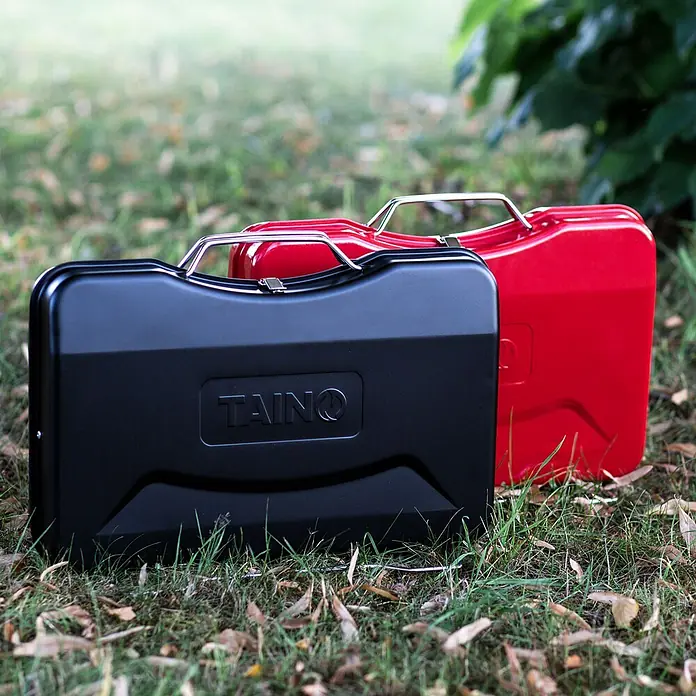 TAINO Holzkohlegrill MOX - Rot - Schwarze und rote Benzinkanister mit Metallgriffen auf Gras.