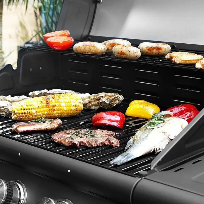 TAINO Gasgrill RED 4+1 - Anzahl Brenner: 4 Stk. - Schwarzer Gasgrill, auf dem verschiedene Lebensmittel wie Fleisch, Fisch, Mais und Gemüse garen.