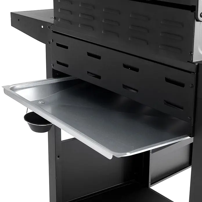 TAINO Gasgrill RED 4+1 - Anzahl Brenner: 4 Stk. - Nahaufnahme einer silbernen ausziehbaren Abtropfschale eines Grills mit einem hängenden schwarzen Fettbehälter, umgeben von schwarzen Metallplatten und Regalen.