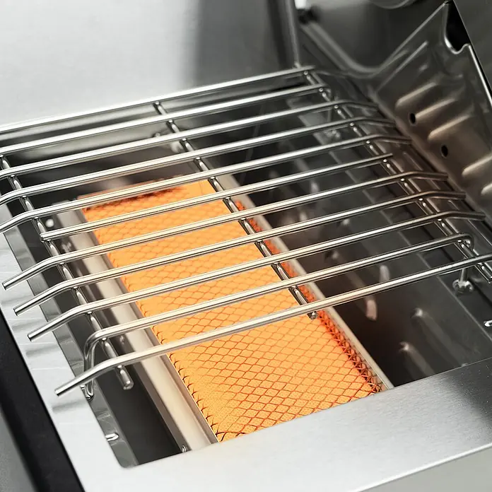 TAINO Gasgrill PLATINUM YAMARA 4+2 - Anzahl Brenner: 4 Stk. - Grillrost aus Edelstahl über einem heißen, orangefarbenen Infrarot-Keramikbrenner mit Rautenmuster.
