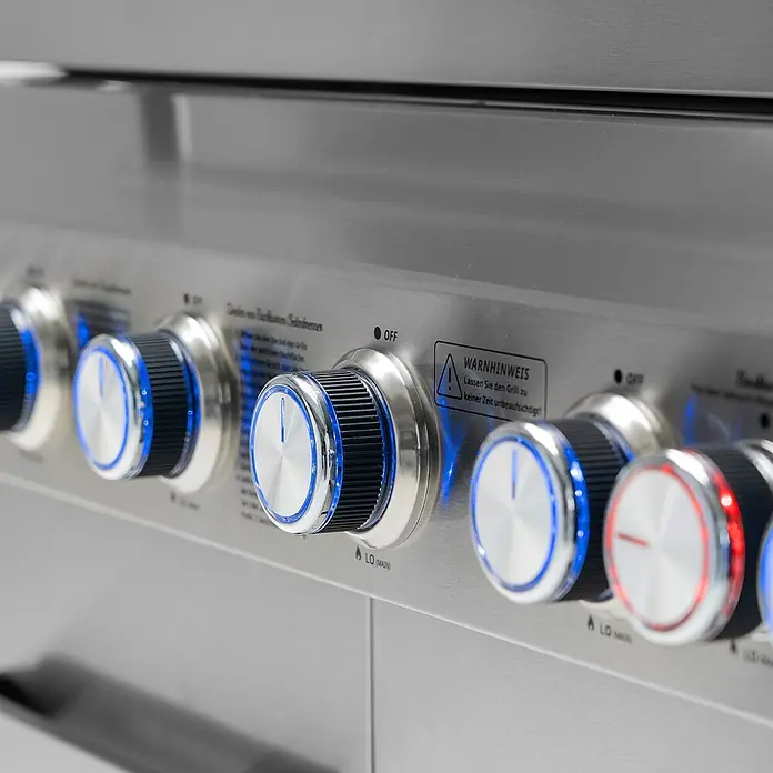 TAINO Gasgrill PLATINUM YAMARA 6+2 - Anzahl Brenner: 6 Stk. - Edelstahl-Grillbedienfeld mit mehreren beleuchteten Chrom- und schwarzen Knöpfen. Text zeigt "OFF" und einen Warnhinweis zur unbeaufsichtigten Benutzung.
