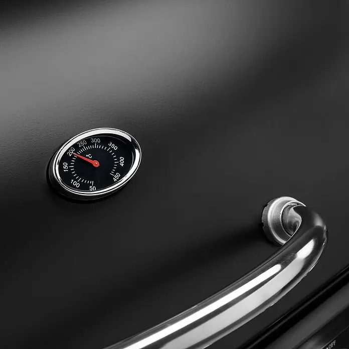 TAINO Gasgrill BASIC 6+1 - Anzahl Brenner: 6 Stk. - Nahaufnahme eines schwarzen Grilldeckels mit silbernem Griff und integriertem Thermometer, das ca. 220°C anzeigt.