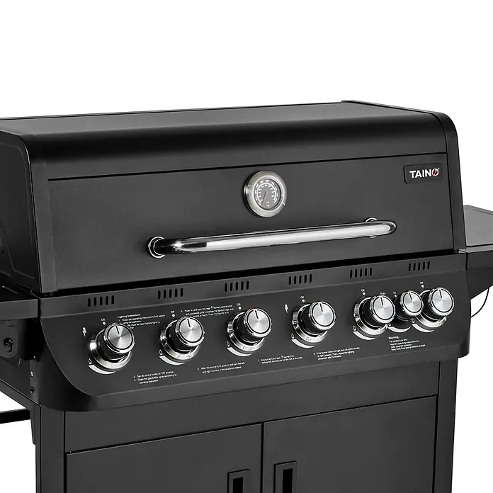 TAINO Gasgrill BRANDO 6+1 - Anzahl Brenner: 6 Stk. - Schwarzer Gasgrill mit eingebautem Thermometer, langem Silbergriff und mehreren silbernen Bedienknöpfen für die Brenner.