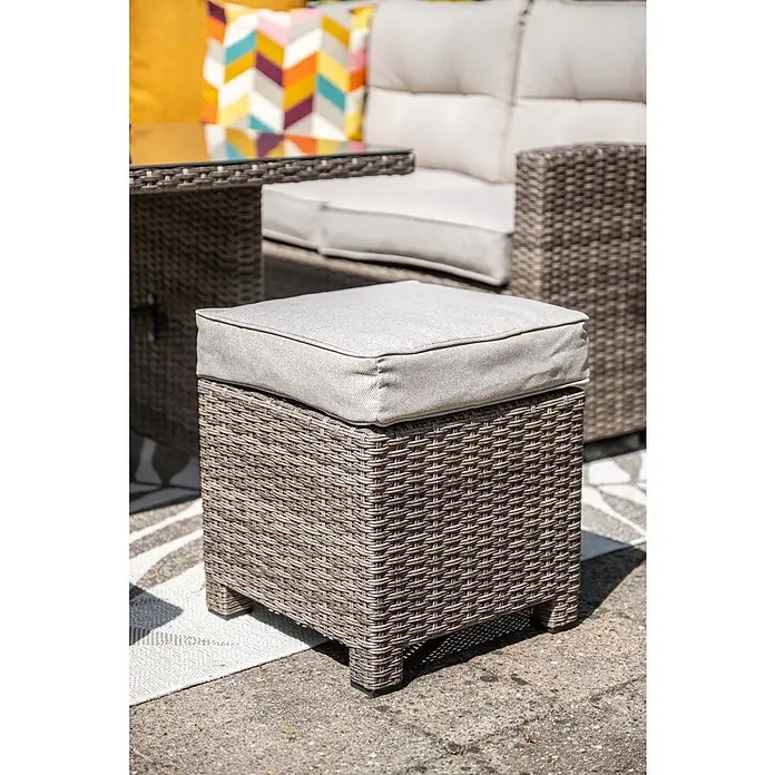 Garden Impressions Loungemöbel-Set Blue Bird - 4 -tlg., Aluminium, Polyester, Sicherheitsglas, Rechts, Beige - Grauer Rattan-Ottomane mit hellgrauem Kissen für den Außenbereich, Teil einer Sitzgruppe.