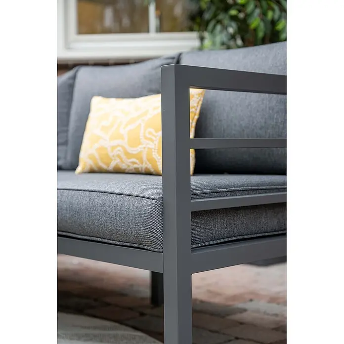 Garden Impressions Loungemöbel-Set Bleco II - 4 -tlg., Aluminium, Anthrazit/Schwarz - Nahaufnahme eines grauen Outdoor-Sofas mit grauen Stoffkissen und einem gelb gemusterten Zierkissen. Mit schlankem grauem Metallgestell.