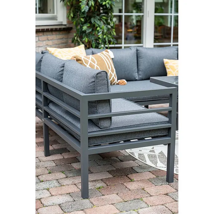 Garden Impressions Loungemöbel-Set Bleco II - 4 -tlg., Aluminium, Anthrazit/Schwarz - Graues Outdoor-Lounge-Sofa aus Metall mit grauen Kissen und gelb-braunen Zierkissen auf gepflasterter Terrasse.