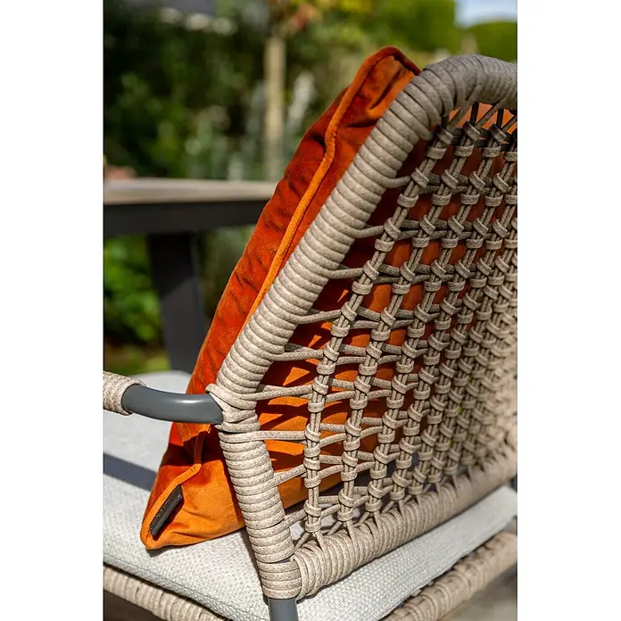 Garden Impressions Gartensessel Swifty - 1 Stk., Stahl, Polyester, Stapelbar, Beige, B x T x H: 63,5 x 84,5 x 56,5 cm - Nahaufnahme eines Gartenstuhls mit geflochtener beiger Seillehne und leuchtend orangefarbenem Samtkissen in einem Garten.