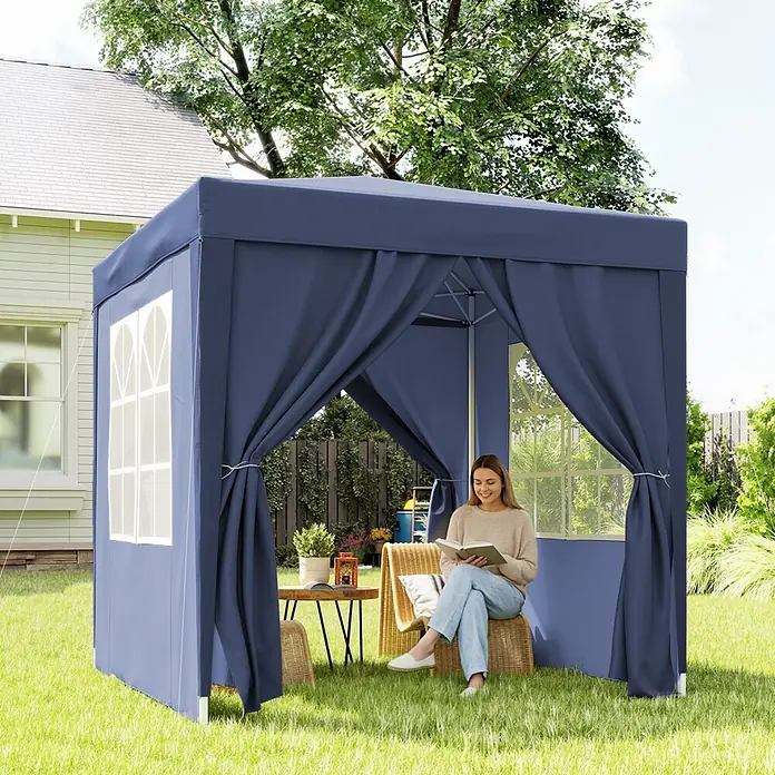 Outsunny Faltpavillon - B x T: 200 x 200 cm, Farbe Dach: Blau - Blaues Outdoor-Pavillonzelt im Garten, mit einer Frau, die bequem darin liest.