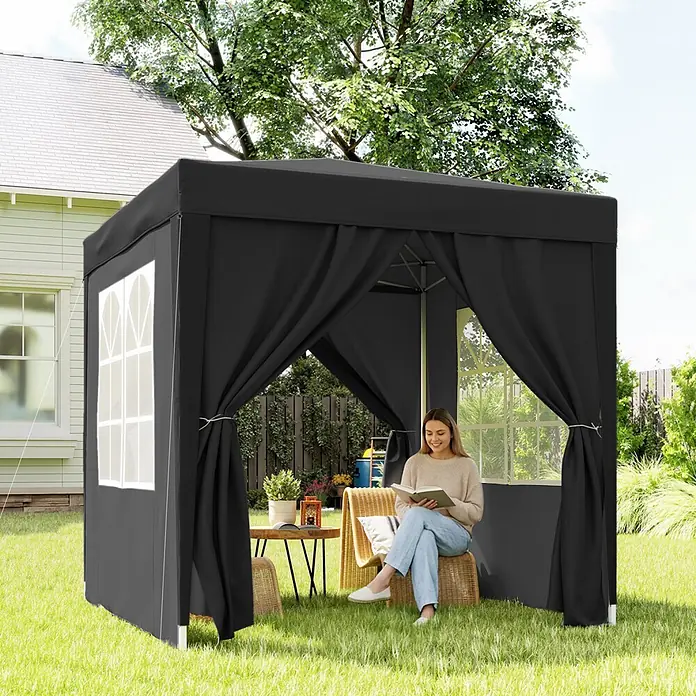 Outsunny Faltpavillon - B x T: 2 m x 200 cm, Farbe Dach: Schwarz - Schwarzer Pavillon aus Stoff im Garten, in dem eine Frau liest und einen komfortablen Schattenplatz bietet.