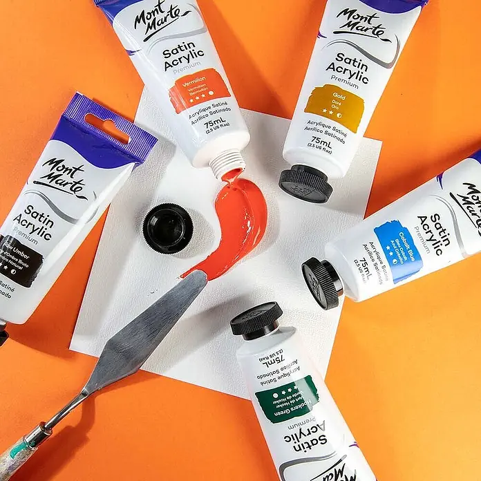 Mont Marte Acrylfarbe Premium - Zinnoberrot, 75 ml, Tube - Mont Marte Satin Acrylfarben-Tuben in verschiedenen Farben, mit Vermillion-Farbe auf einem Spachtel auf weißer Palette.
