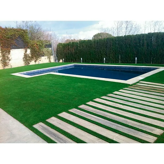Césped artificial Bogotá - 5 x 1 m, Altura del pelo: 30 mm, 15.750 puntadas/m² - Zona de césped con piscina y terraza de madera. El césped verde crea un ambiente acogedor, mientras que la terraza de madera aporta un toque elegante.