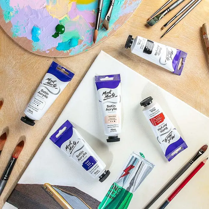 Mont Marte Acrylfarbe Premium - Gelbrosa, 75 ml, Tube - Mont Marte Satin Acrylfarben-Tuben in verschiedenen Farben, auf einer Leinwand mit Pinseln und Palette, bereit zum Malen.
