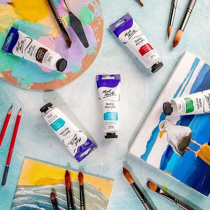 Mont Marte Acrylfarbe Premium - Himmelblau, 75 ml, Tube - Mont Marte Satin Acrylfarben, Pinsel, Palette und Leinwände für ein Kunstprojekt arrangiert.