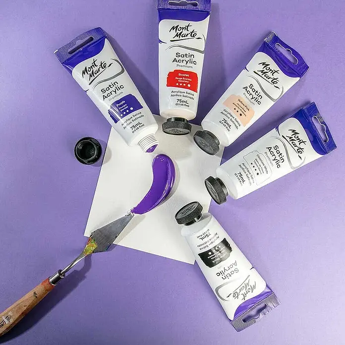 Mont Marte Acrylfarbe Premium - Violett, 75 ml, Tube - Mont Marte Satin Acrylfarben Tuben in verschiedenen Farben, eine mit violetter Farbe auf Papier und einem Malspachtel.