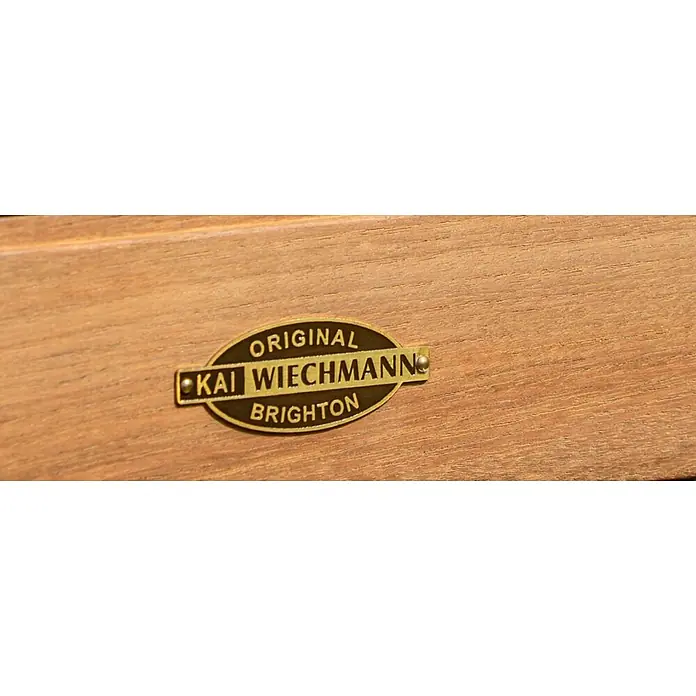 Kai Wiechmann Gartenhocker - Teakholz, Höhenverstellbar, braun - Messingfarbenes Metallschild mit der Aufschrift „ORIGINAL KAI WIECHMANN BRIGHTON“ auf hellem Holz befestigt.