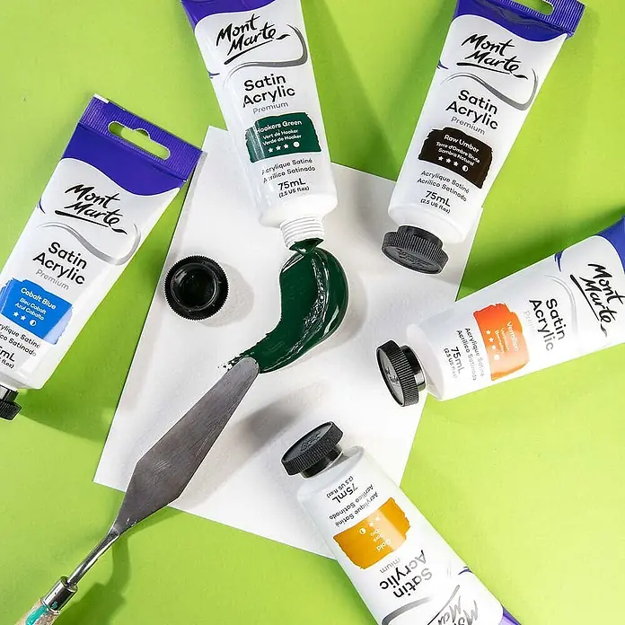 Mont Marte Acrylfarbe Premium - Hookers Grün, 75 ml, Tube - Mont Marte Satin Acrylfarben-Tuben in verschiedenen Farben, teils geöffnet mit Farbe auf einem Spachtel.