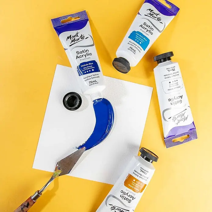 Mont Marte Acrylfarbe Premium - Phthaloblau, 75 ml, Tube - Mont Marte Satin Acrylfarben in Tuben, verschiedene Farben. Eine Tube drückt blaue Farbe auf eine weiße Fläche, mit einem Spachtel verteilt.